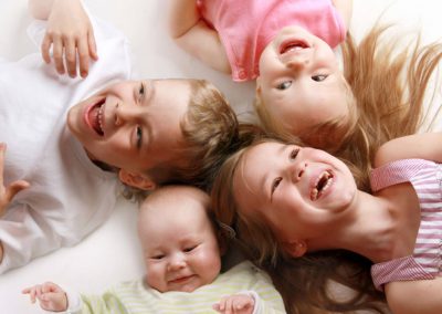 3 kids and a baby lying down