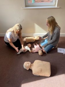 Two sisters learning Baby First Aid Bolton